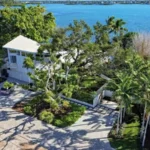Aerial view of a restored 1950s waterfront home in Siesta Key featuring lush tropical landscaping and mature canopy trees